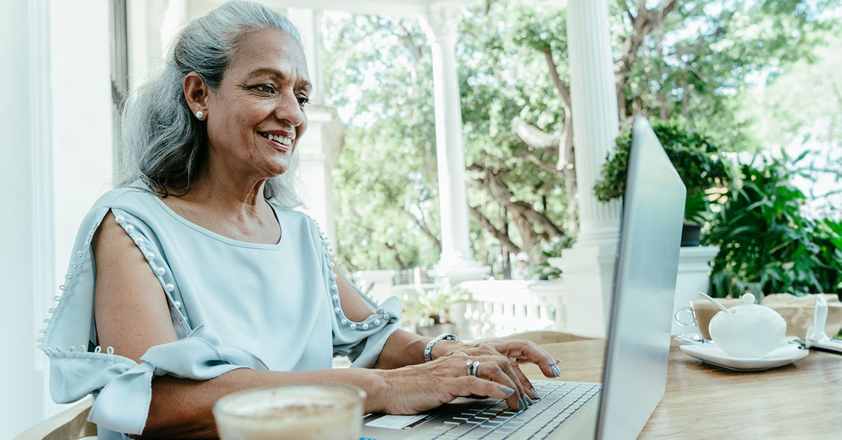 An agent working on a laptop while having a latte