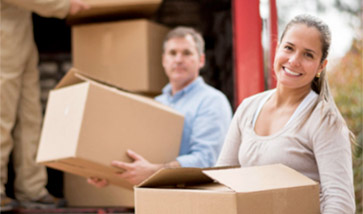 smiling couple loads boxes on truck